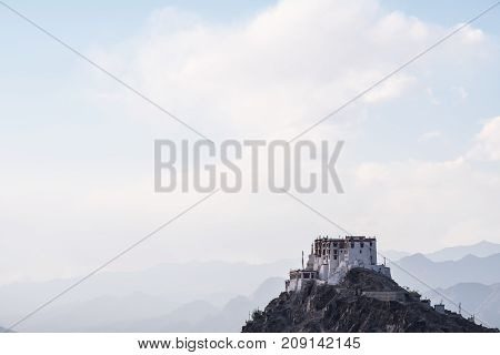 Stakna Gompa on the top of mountain with blue and cloudy sky background