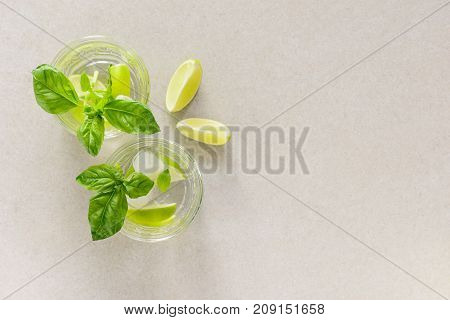 Basil and ginger limeade in two glasses overhead view minimal composition with a space fpr a text