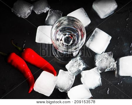 A Shot Of Vodka, An Alcoholic Beverage, Next To Ice, Fire, Ice, Red Chili Pepper. The Concept Of Alc