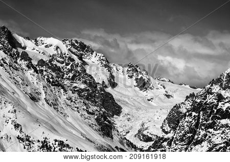 Black and white mountains with glacier in snow at winter sun day. View from ski lift on Hatsvali Svaneti region of Georgia. Caucasus Mountains.