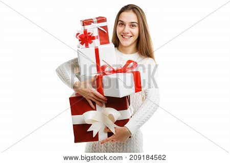 Beautiful smiling girl with a long hair posing on the camera in studio and holding christmas gift isolated on white background. Close-up of gifts. Holiday concept.