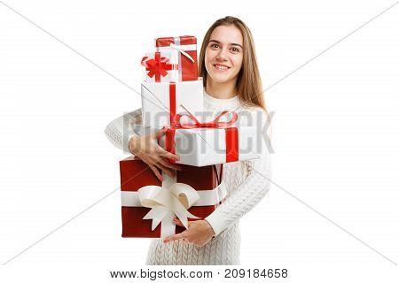 Beautiful smiling girl with a long hair posing on the camera in studio and holding christmas gift isolated on white background. Close-up of gifts. Holiday concept.