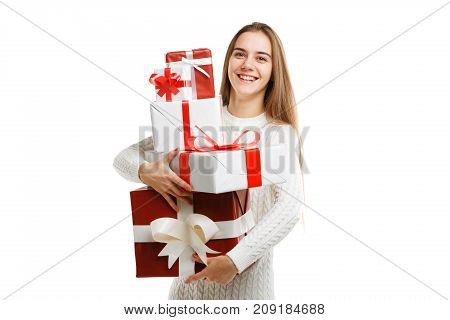 Pretty cutie girl with a long hair posing on the camera in studio and holding christmas gift isolated on white background. Close-up of gifts. Holiday concept.