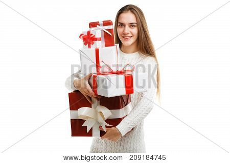 Pretty cutie girl with a long hair posing on the camera in studio and holding christmas gift isolated on white background. Close-up of gifts. Holiday concept.