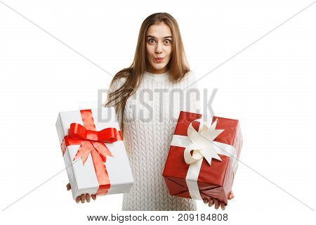 Pretty cutie girl with a long hair posing on the camera in studio and holding christmas gift isolated on white background. Close-up of gifts. Holiday concept.