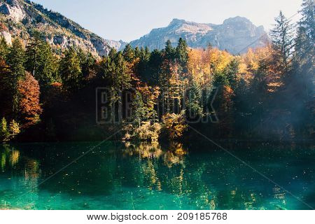 Autumn time at romantic forest lake blausee, one of the best known mountain lakes in Switzerland.