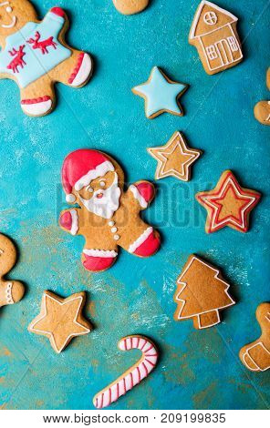 Ginger men with colored glaze on a turquoise background .. Gingerbread. Christmas cookies. Ginger man in a colored sweater. Gingerbread Santa