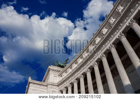 National Monument to Victor Emmanuel II first King of Italy (Altar of Nation) a neoclassical structure designed by italian architect Sacconi in 1885 with blue sky and clouds