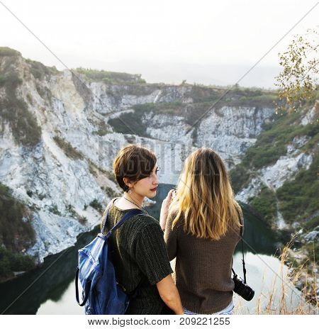 Girlfriends standing in rear view on top of the mountain