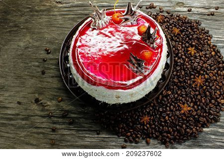 big cake and coffee beans, anise and cinnamon on a wooden table. view from above