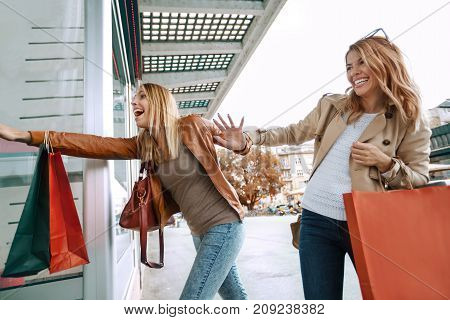 Black friday concept.Happy friends shopping. Two beautiful young women enjoying shopping in the city.