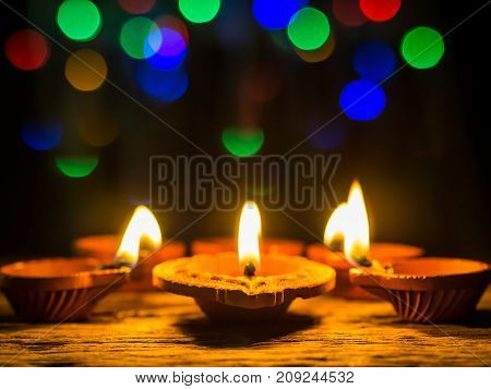Happy Diwali - Diya lamps lit with bokeh background during diwali celebration.