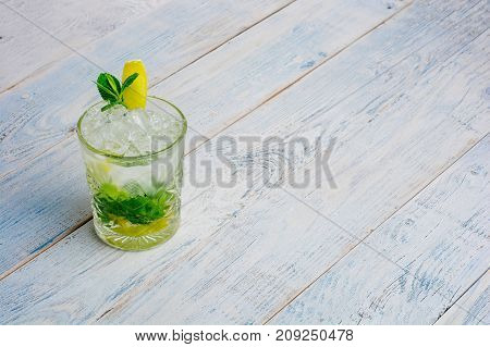 Alcohol mojito cocktil bar long drink fresh tropical beverage top view copy space highball glass, with rum, spearmint, lime juice, soda water and ice on white concrete table .
