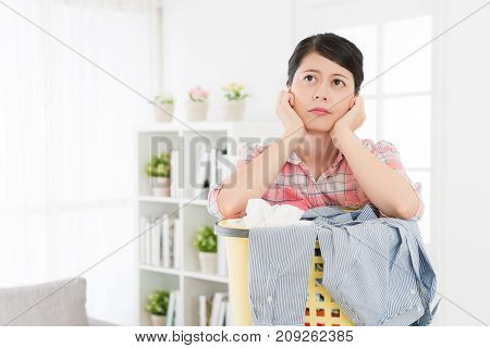 Woman Leaning On Laundry Basket Feeling Bored