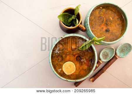 Solyanka Soup With Meat, Smoked Meat, Sausages, Pickled Cucumbers, Tomatoes, Olives, Herbs, Lemon In