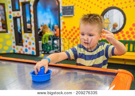 little kid plays in air hokey in Entertainment Center