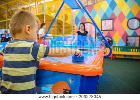 little kid plays in air hokey in Entertainment Center