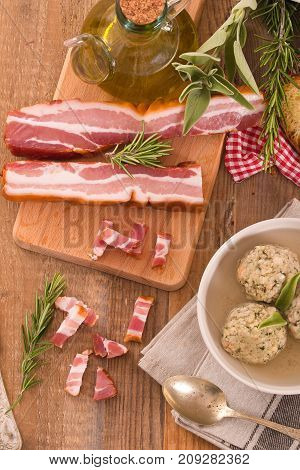 Canederli pasta with bacon on cutting board.