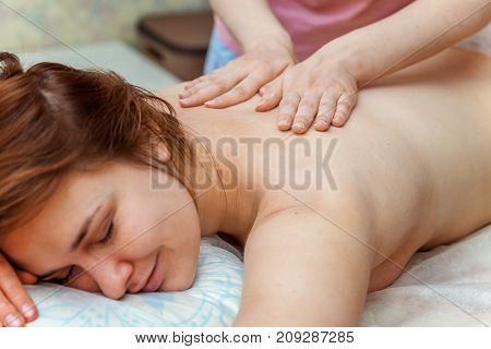 Beautiful young girl having massage in spa salon