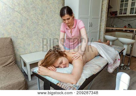 Beautiful young girl having massage in spa salon