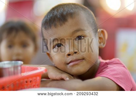SHIRA THANI, THAILAND, SEPTEMBER 28, 2016 : A shy little boy is posing in the night market of Shira Thani, Isaan ,Thailand
