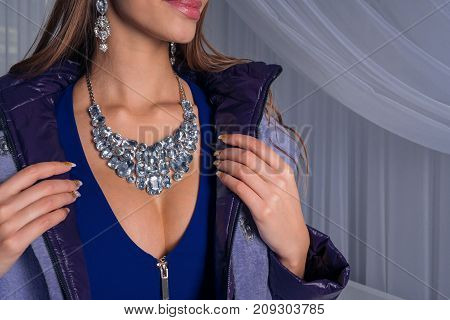 Sexy girl in an expensive fur coat in jewelry with diamonds