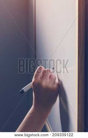 Hand writing on whiteboard surface - office business and education concept
