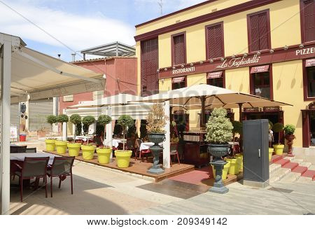 FIGUERES, SPAIN - JULY 26, 2017: People at outdoors terrace of restaurant in plaza located in Figueres a city of Girona Catalonia Spain.
