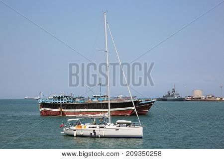GULF OF ADEN, DJIBOUTI: FEBRUARY 08, 2016: Luxury sailing boat, fishing and cargo ships at anchor in the port of Djibouti
