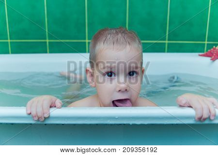 Boy in white bath tub on white background
