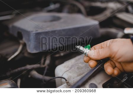 auto mechanic keeps the spark plugs in the glove. Concept car diagnostics