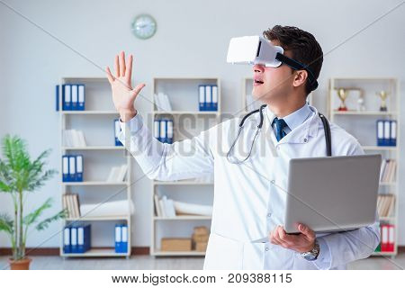 Young doctor with vr virtual reality headset working in the offi
