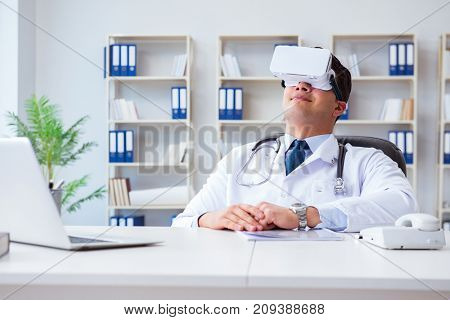 Young doctor with vr virtual reality headset working in the offi