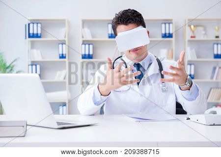 Young doctor with vr virtual reality headset working in the offi