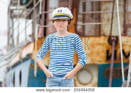 Portrait of a boy in a striped long sleeve T-Shirt (Telnyashka) and captain's cap.