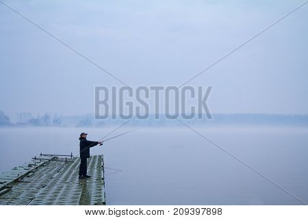 BELGRADE SERBIA - JANUARY 18 2015: Fisherman fishing on the Danube river during a heavily foggy winter afternoon in Zemun a northern district of Belgrade