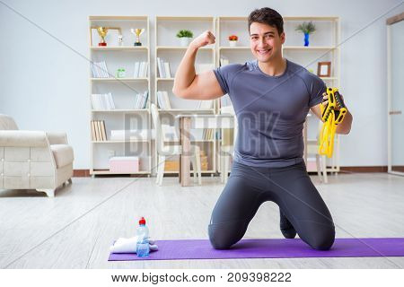 Young man exercising at home in sports and healthy lifestyle con