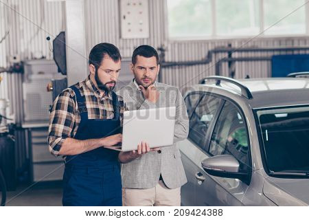 Experienced Brunet Bearded Expert Specialist In Blue Overall And Checkered Shirt Is Demonstrating Th