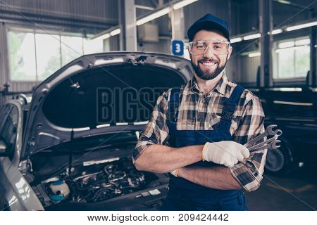 Attractive Caucasian Brunet Bearded Expert Mechanic Standing With Metal Mechanical Keys In Arm, In S