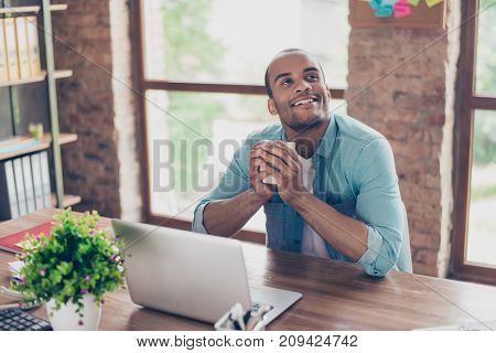 Young Dreaming Mulatto American Worker Is Thinking In Front Of Laptop At Work Place. He Is Happy, Sm