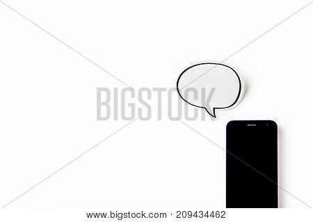 Business concept - Top view of modern office desktop background with blank bubble sticker and smart phone for mockup design and copy space isolated on white background