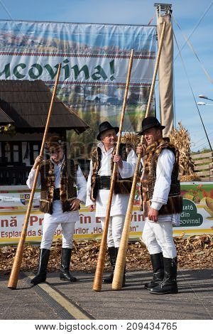 Men In Traditional Costume Playing On Alpenhorns