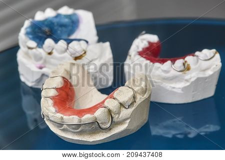 Colorful dental braces or retainers for teeth on black glass background closeup