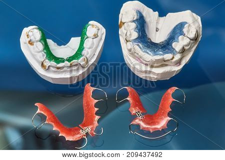 Colorful dental braces or retainers for teeth on black glass background closeup