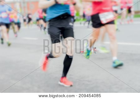 Close-up of feets legs of running athletes on street city marathon blur effect. Sport fitness healthy lifestyle concept