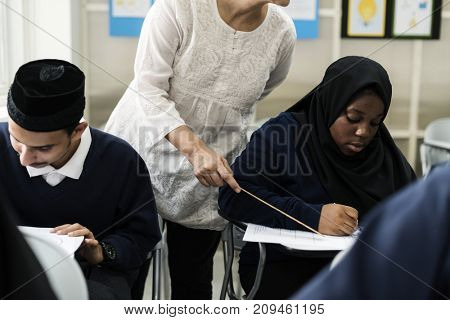 diverse muslim children studying in classroom
