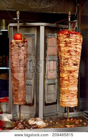 Turkish chicken and meat doner grilled on a vertical rotisserie.