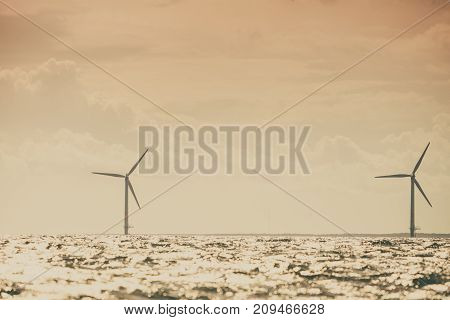 Vertical axis wind turbines generator farm for renewable sustainable and alternative energy production along coast baltic sea near Denmark. Eco power ecology.