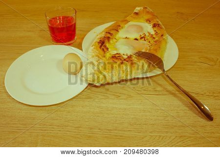 Adjarian khachapuri on a on a plate. Open pie with cheese in the shape of the boat. Delicious homemade khachapuri in Adjarian - Retro color