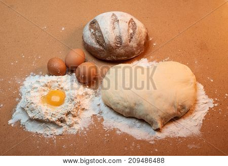 Dough In The Shape Of A Heart, Round Bread, Three Eggs, And The Yolk Surrounded By Flour